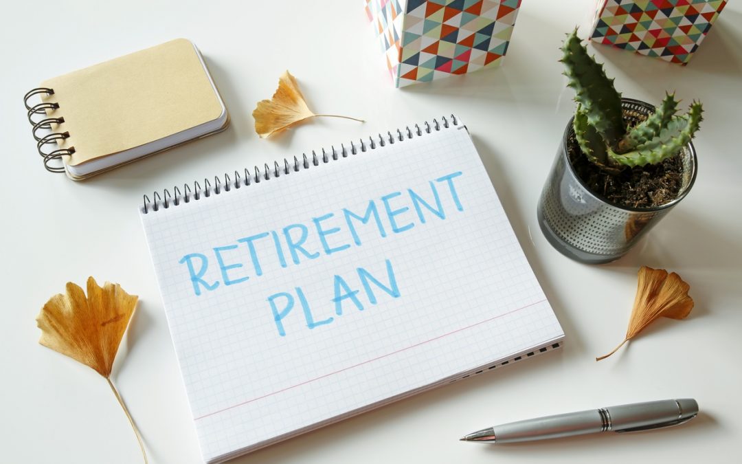 Retirement plan written in notebook on white table to illustrate traditional vs. Roth IRA